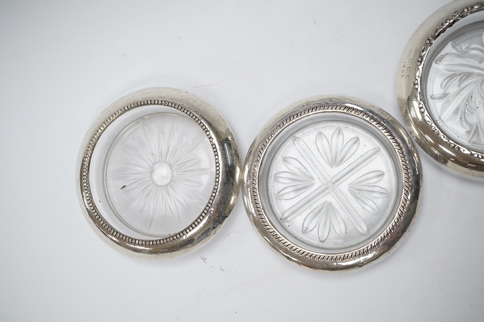 A set of four silver rimmed cut glass coasters, diameter 93mm. Condition - poor